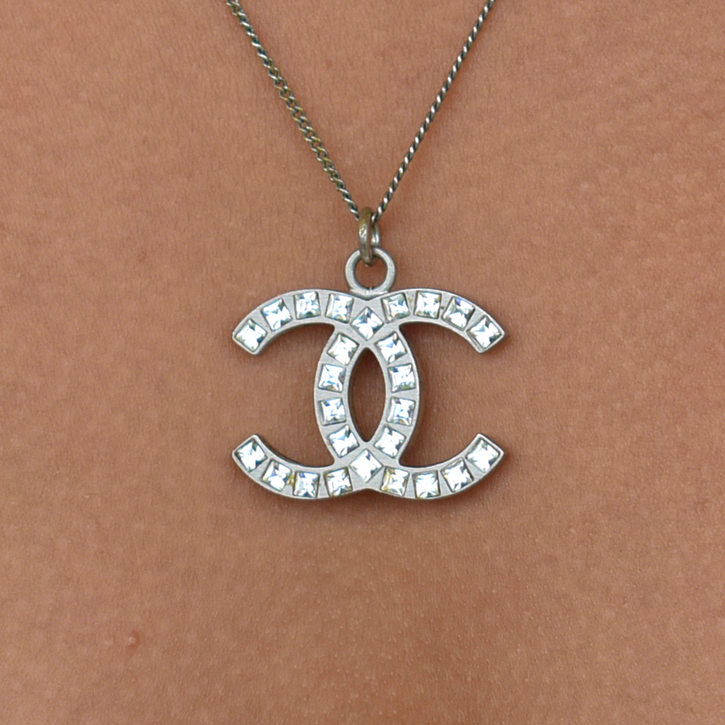 Close-up of model wearing silver Chanel CC rhinestone necklace