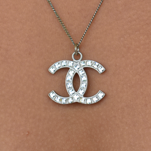 Close-up of model wearing silver Chanel CC rhinestone necklace