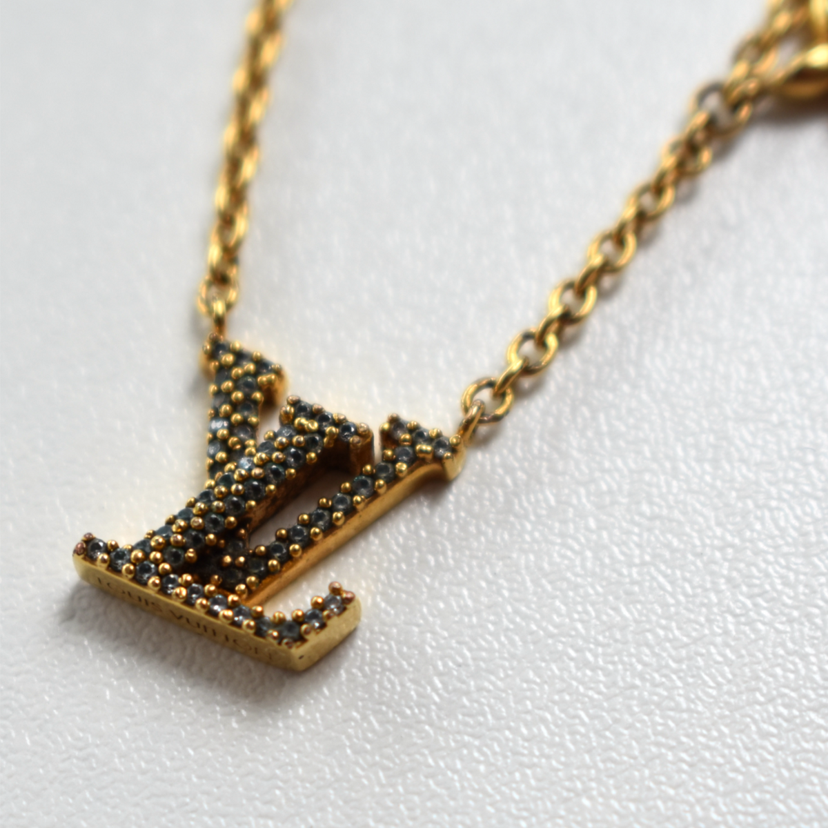 Close-up of gold Louis Vuitton rhinestone pendant
