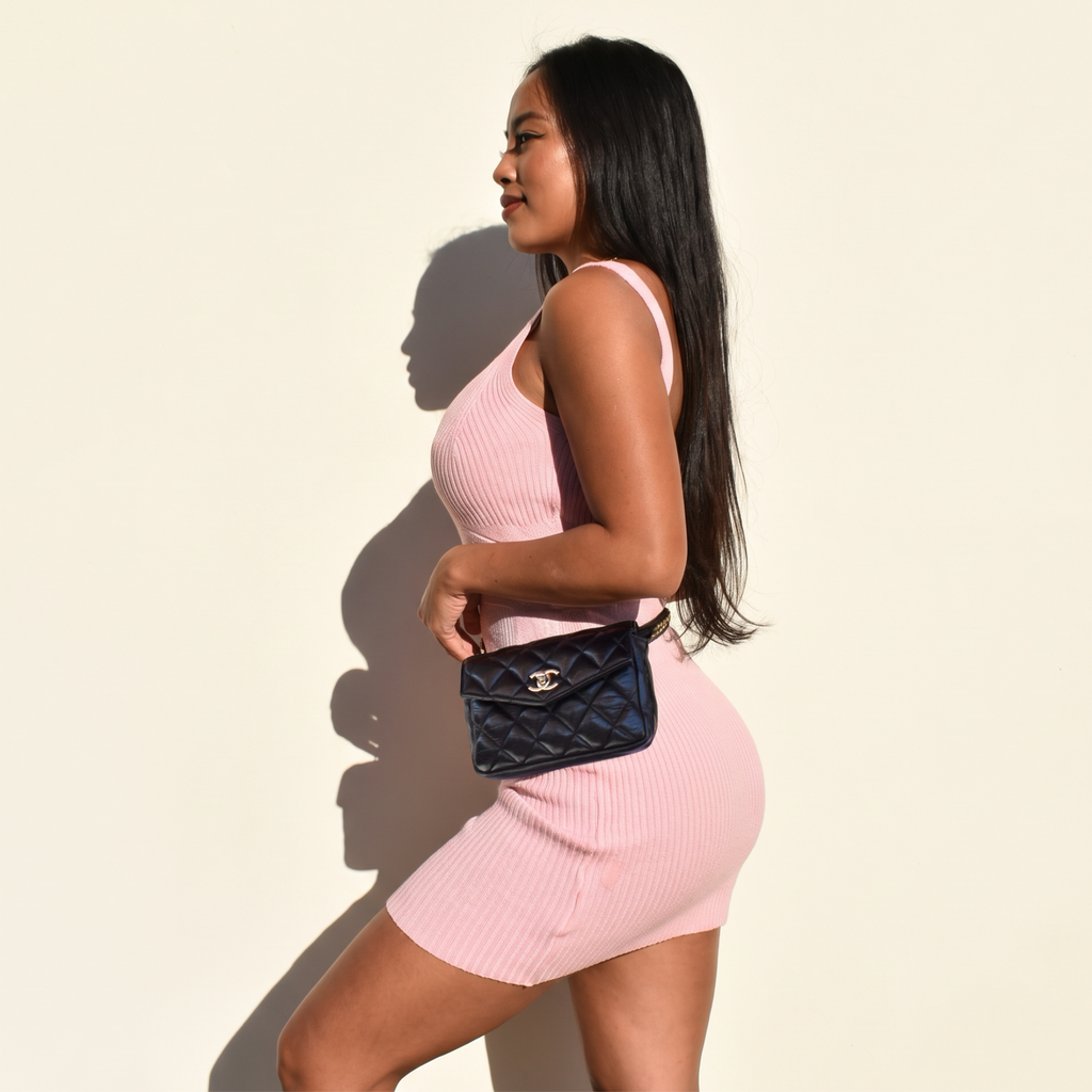 Model wearing vintage black Chanel Turnlock belt bag, wider side view