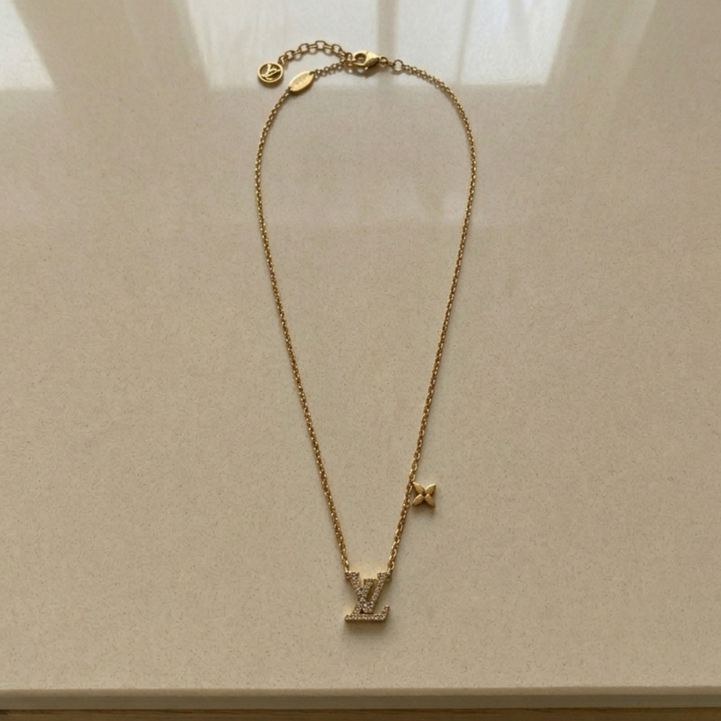 Gold Louis Vuitton Iconic rhinestone necklace styled flat lay