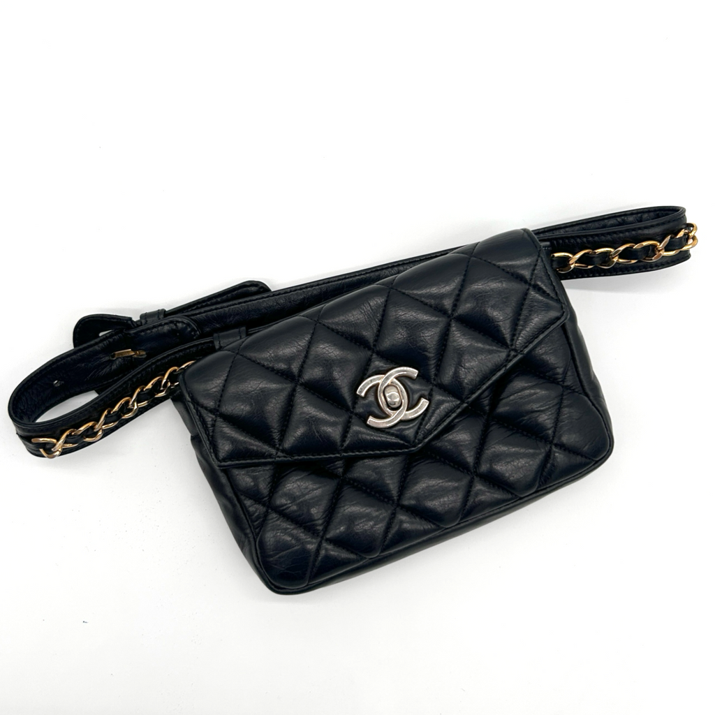 Vintage black Chanel Turnlock matelassé belt bag laid flat, front view