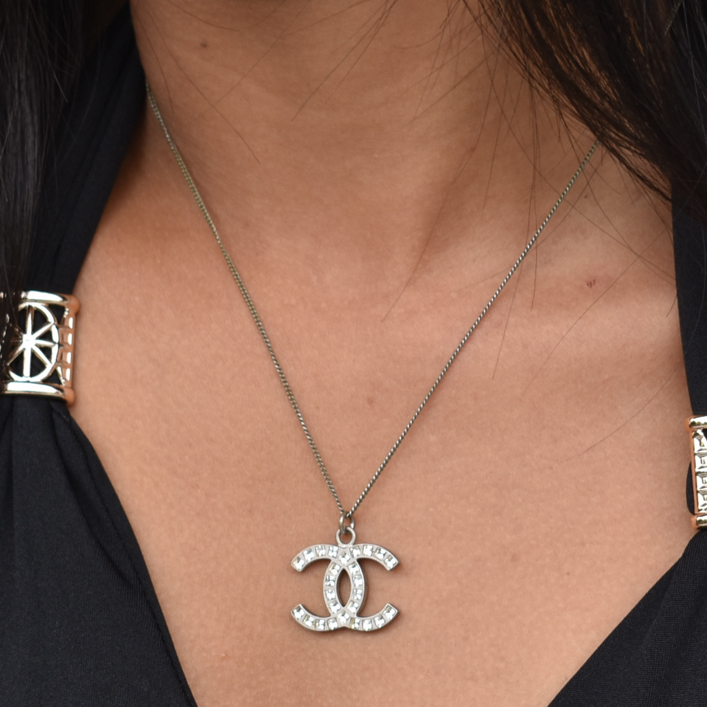 Model wearing silver Chanel CC rhinestone necklace, mid-length view
