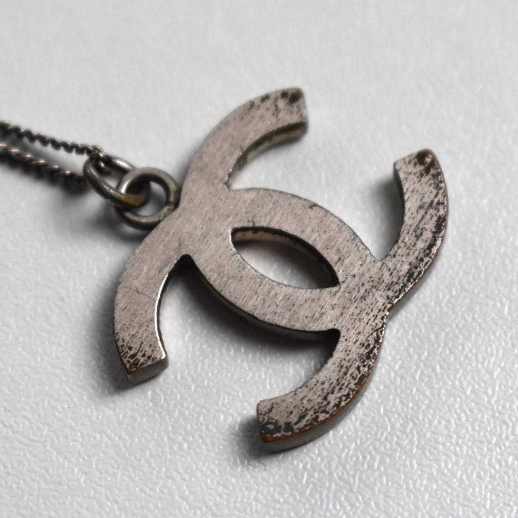 Back of silver Chanel CC necklace pendant showing minor wear