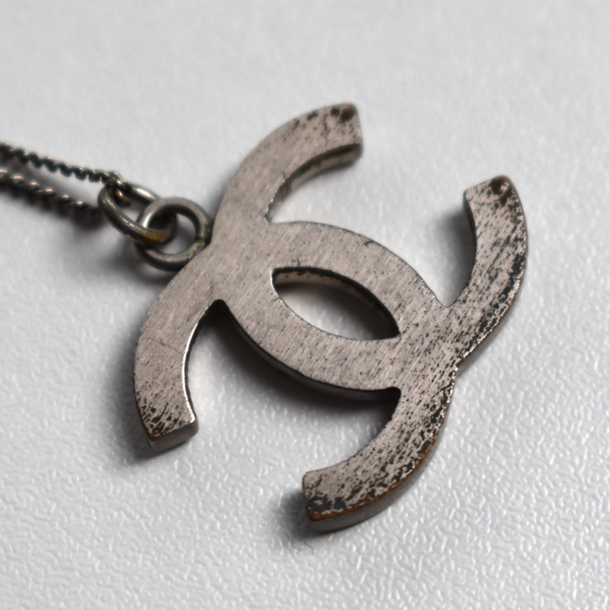 Back of silver Chanel CC necklace pendant showing minor wear