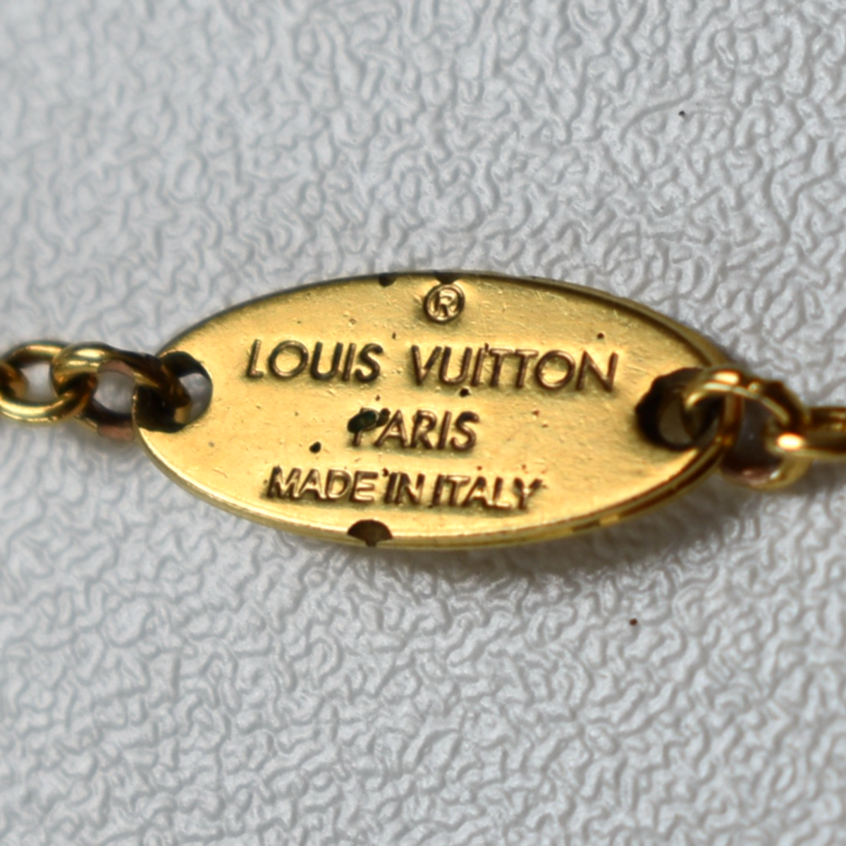 Louis Vuitton branding and Made in Italy engraving on gold rhinestone necklace